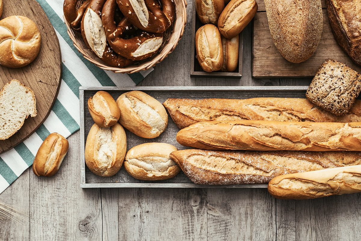 Freshly baked delicious bread on a rustic wooden worktop 