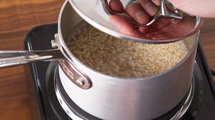 person showing how to cook brown rice