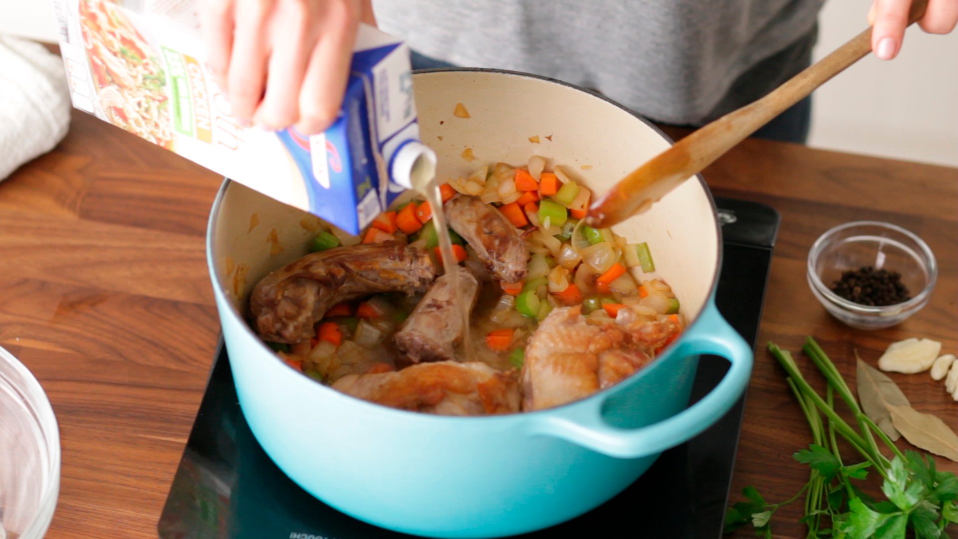Chicken stock being added to the turkey bone and diced vegetables