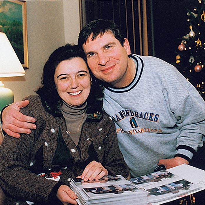 Man and woman hugging over a photo book of Christmas memories