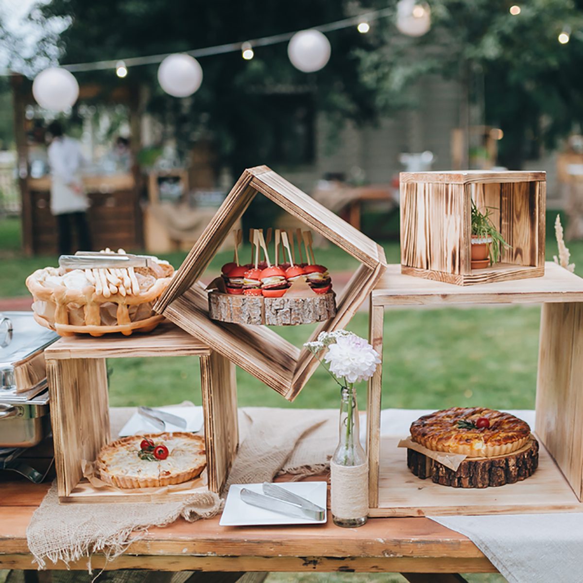 on decorated buffet table in wooden boxes are cakes and snacks; Shutterstock ID 314779967