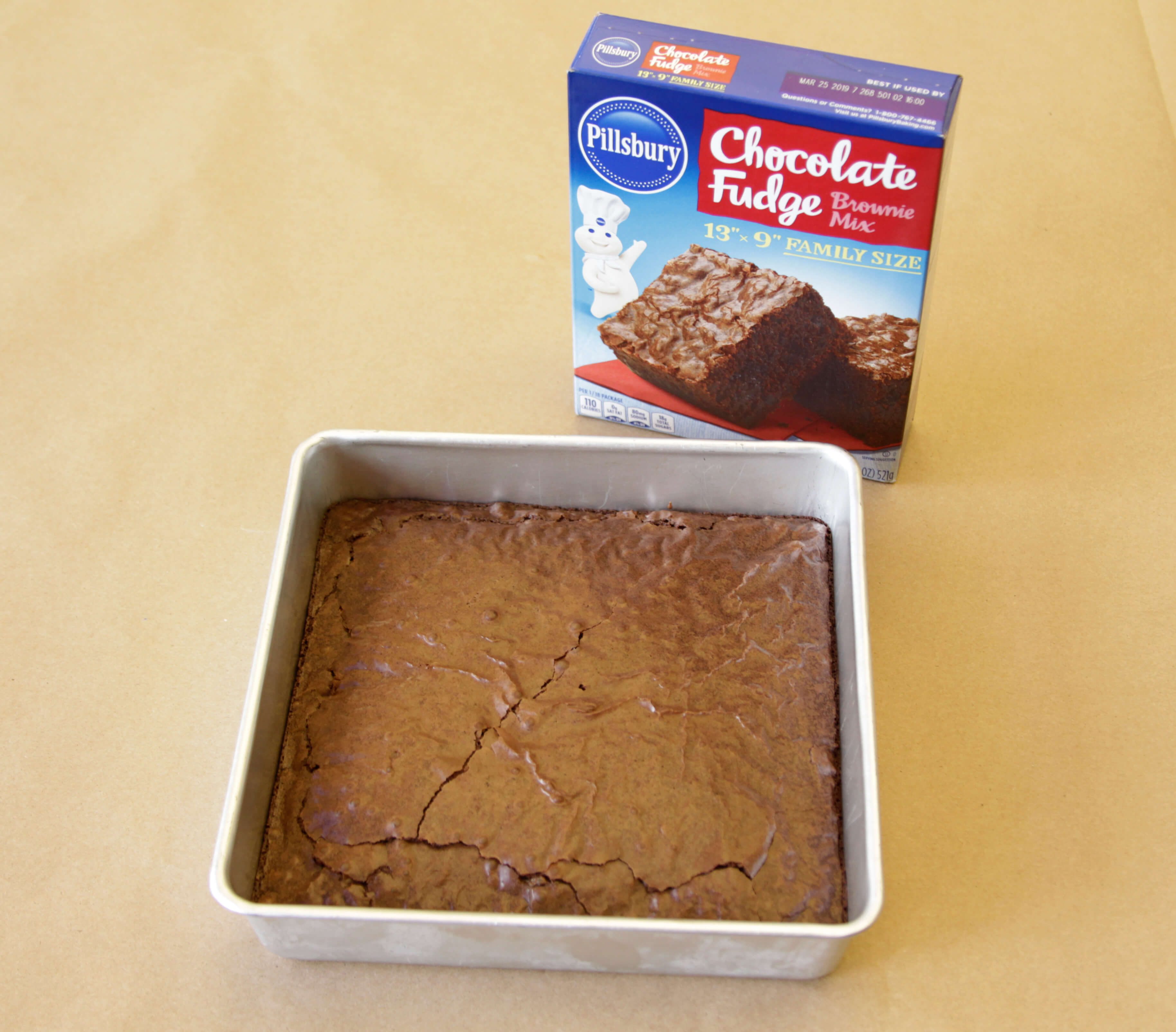 Pillsbury brand brownies in a pan beside its packaging