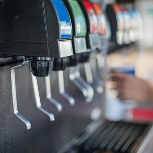 Person pouring water at a drink fountain