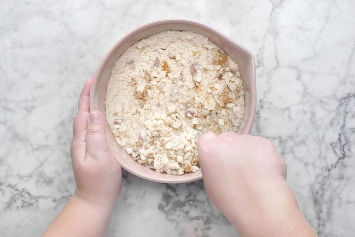 Flour, brown sugar, chopped walnuts mixed inside a bowl