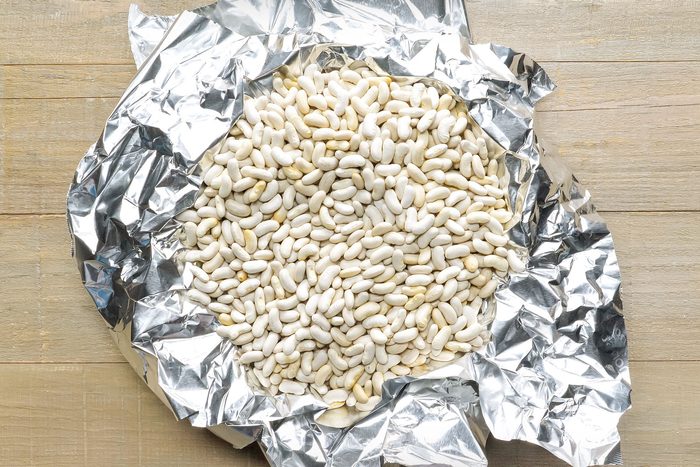 Dried Beans in Silver Foil on Wooden Surface