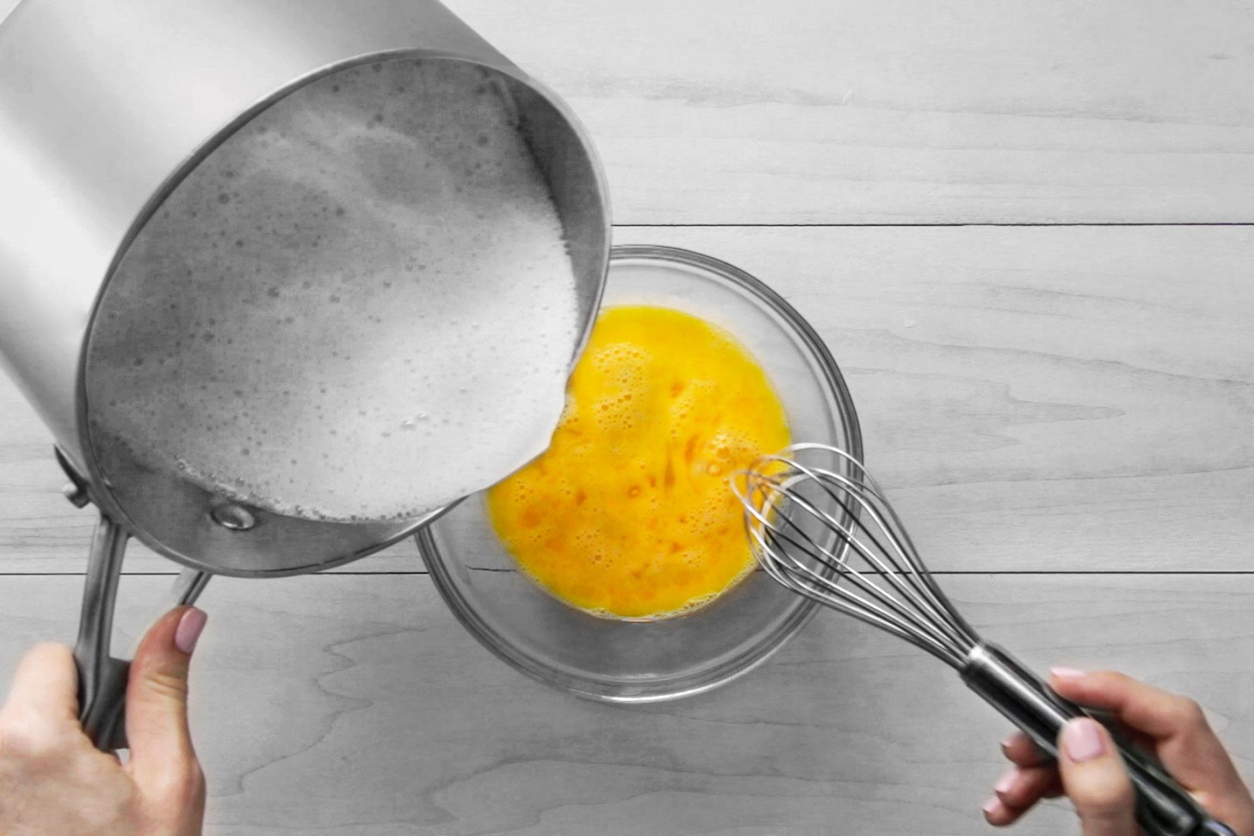 Pouring flour and milk mixture into beaten eggs