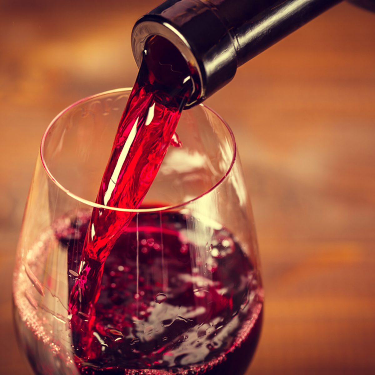 Pouring red wine into the glass against wooden background; Shutterstock ID 374546602; Job (TFH, TOH, RD, BNB, CWM, CM): TOH