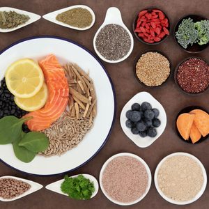 Large health food selection in bowls over lokta paper background