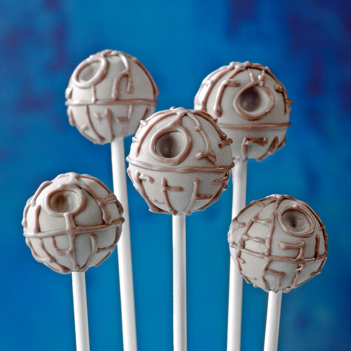Death Star Truffles; eyelevel; low camera angle; gray surface; blue background; cakepop; candy; chocolate; truffle; star wars; May the 4th be with you; party; blue ceramic pot