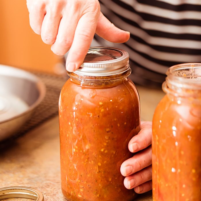Band being screwed onto the jar as part of the canning process
