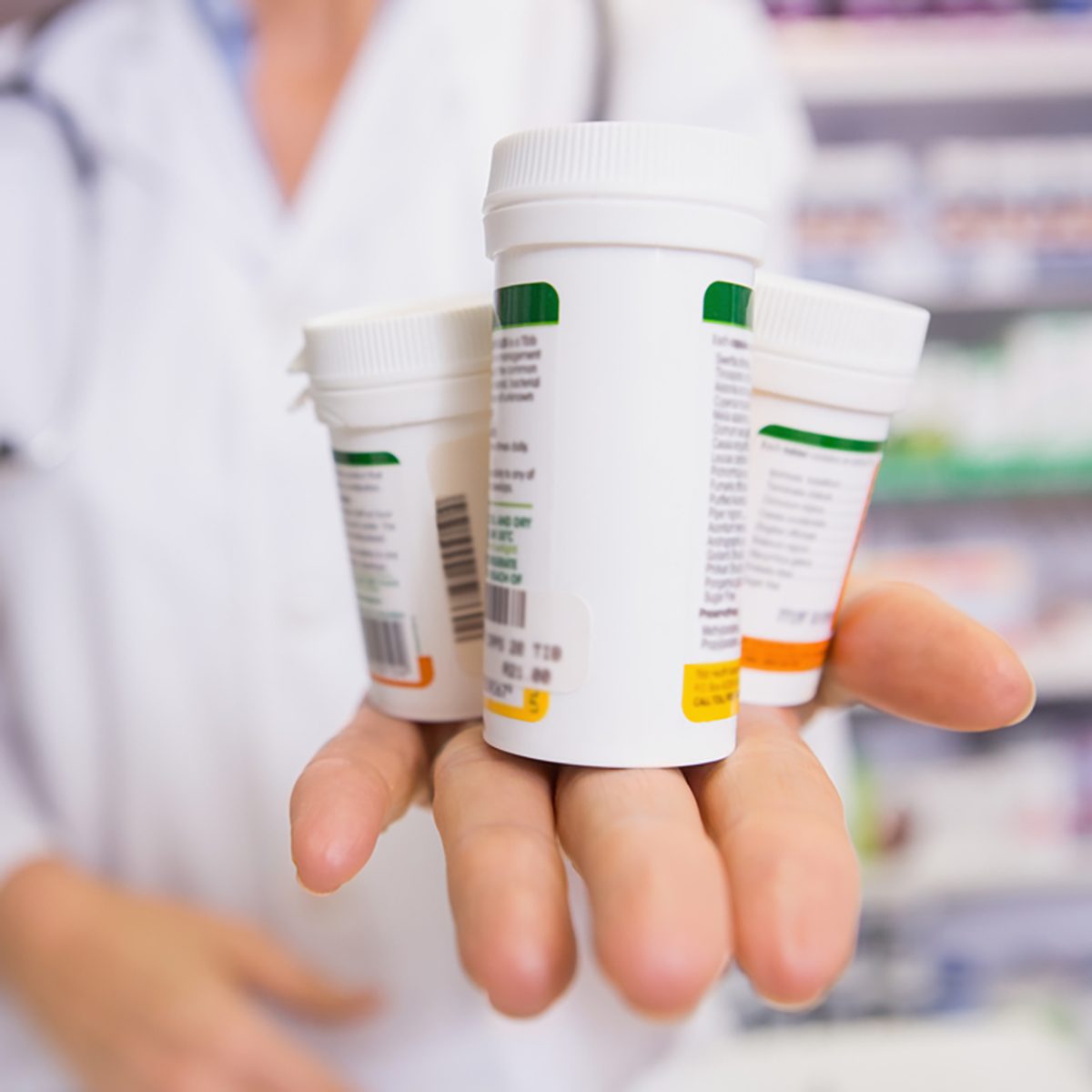 Pharmacist presenting medications on her hand in the pharmacy