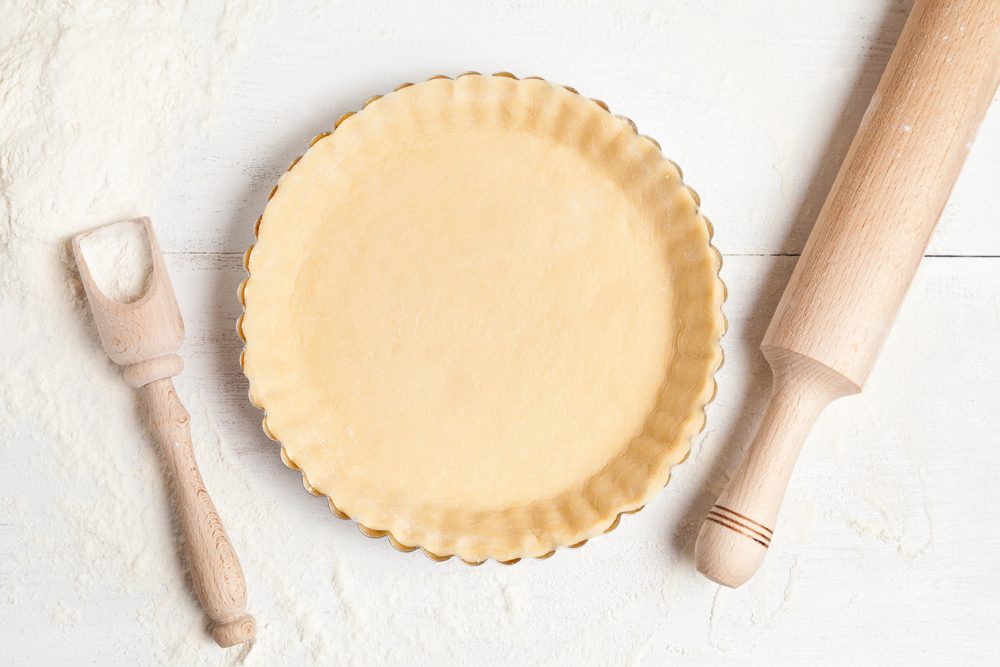 Homemade tart pie preparation, dough with yeast and rolling pin on white rustic kitchen table