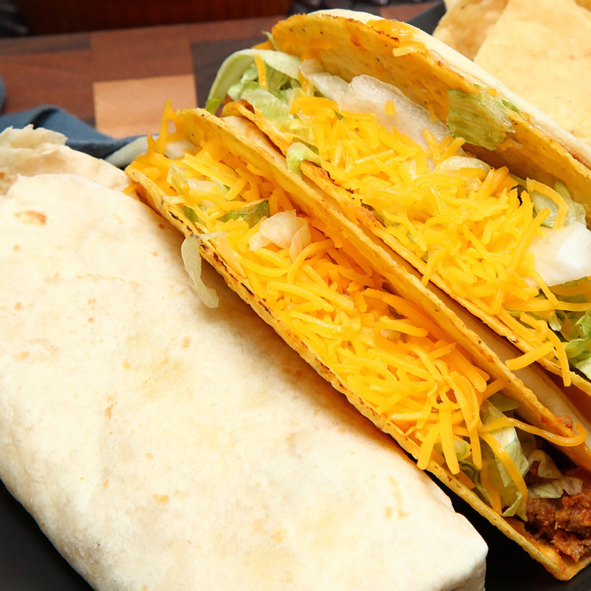 Burrito, Taco, Gordita Crunch and Nachos with Cheese Sauce on Dish.