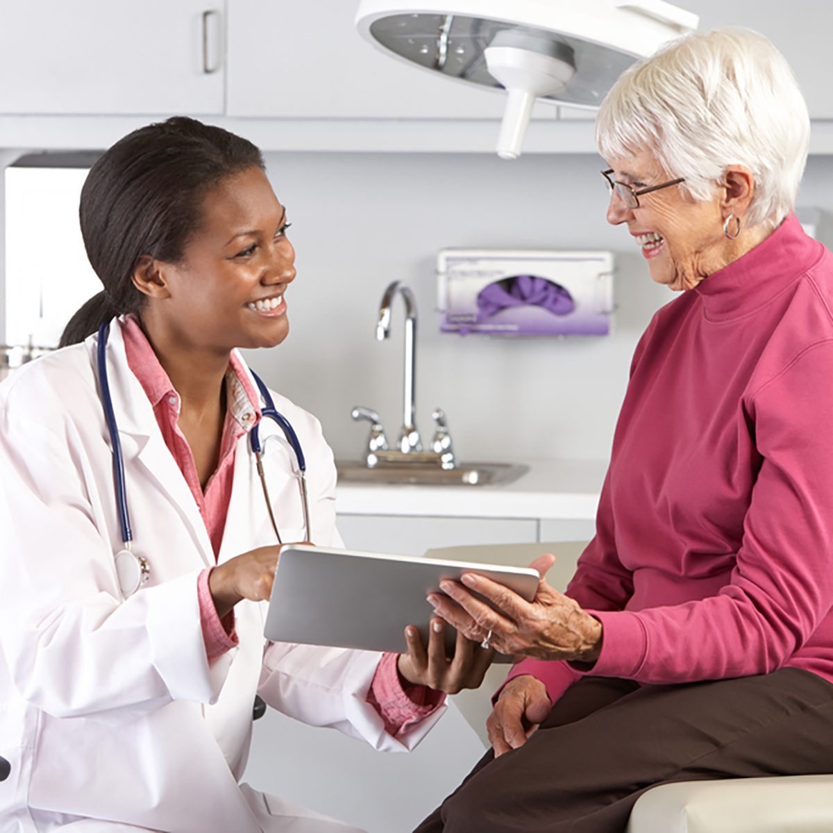 Doctor Discussing Records With Senior Female Patient;