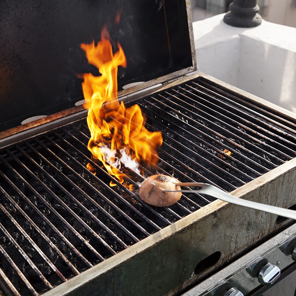 Getting the grill ready for some cooking - rubbing halved onion on the hot grate.