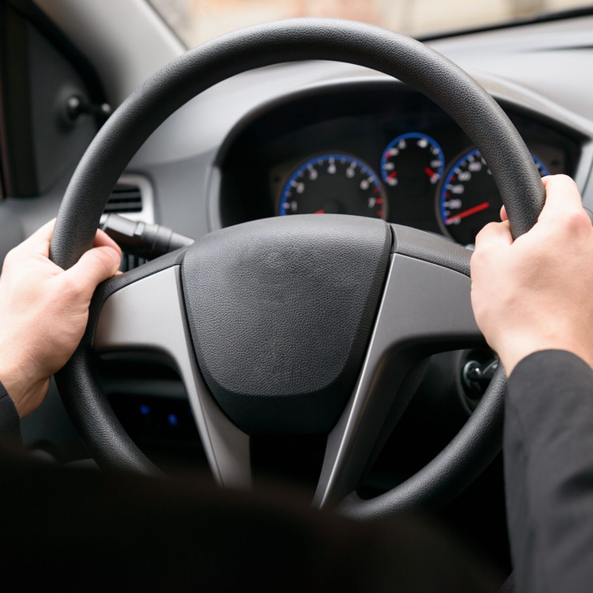 Close-up Of A Man Hands Holding Steering Wheel While Driving Car