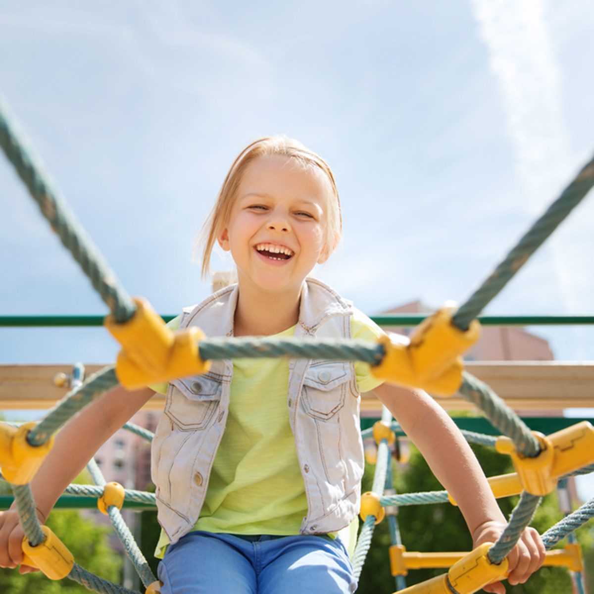 happy little girl on children playground climbing frame