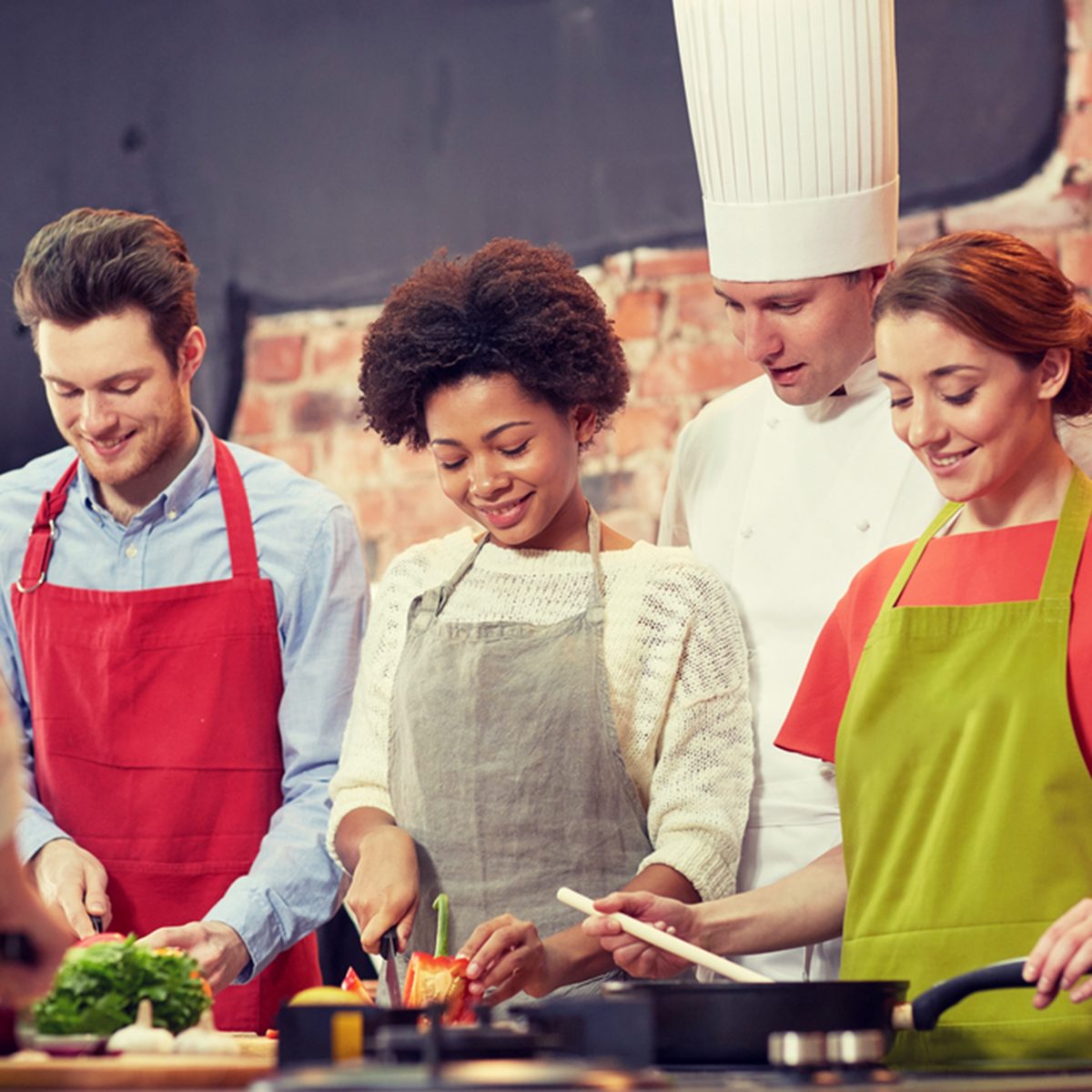happy friends and chef cook cooking in kitchen