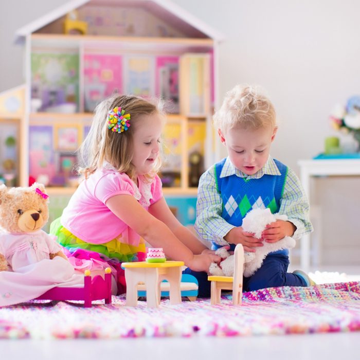 Kids playing with doll house and stuffed animal toys.