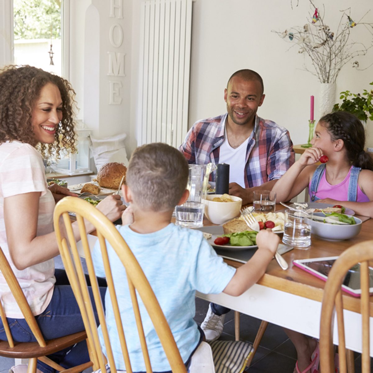 Family At Home Eating Meal In Kitchen Together