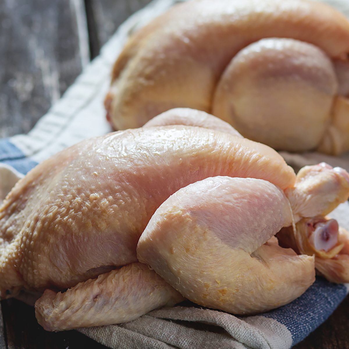 Two Raw mini Chicken on kitchen towel over old wooden table. Dark rustic style. Natural day light.; Shutterstock ID 340672502; Job (TFH, TOH, RD, BNB, CWM, CM): Taste of Home