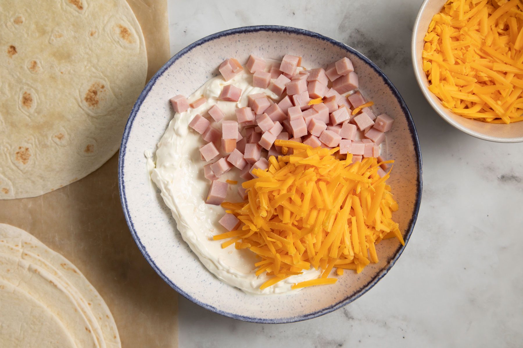 cheddar cheese and ham mixed inside a bowl