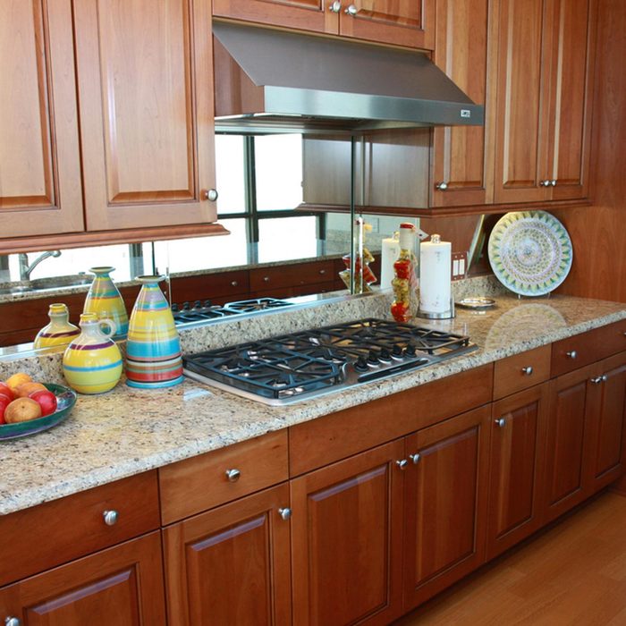 Kitchen with wooden cabinets and a mirror backsplash
