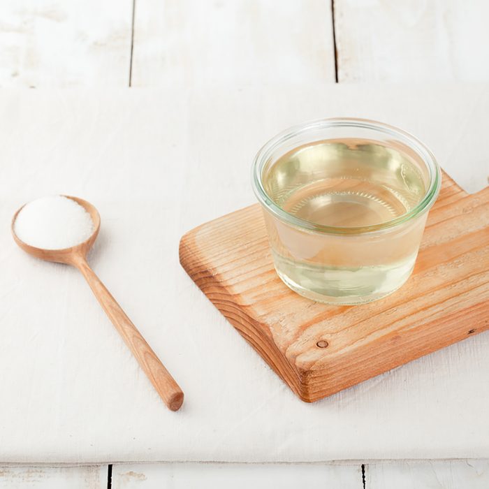 Sugar syrup in a glass bowl on a white wooden background