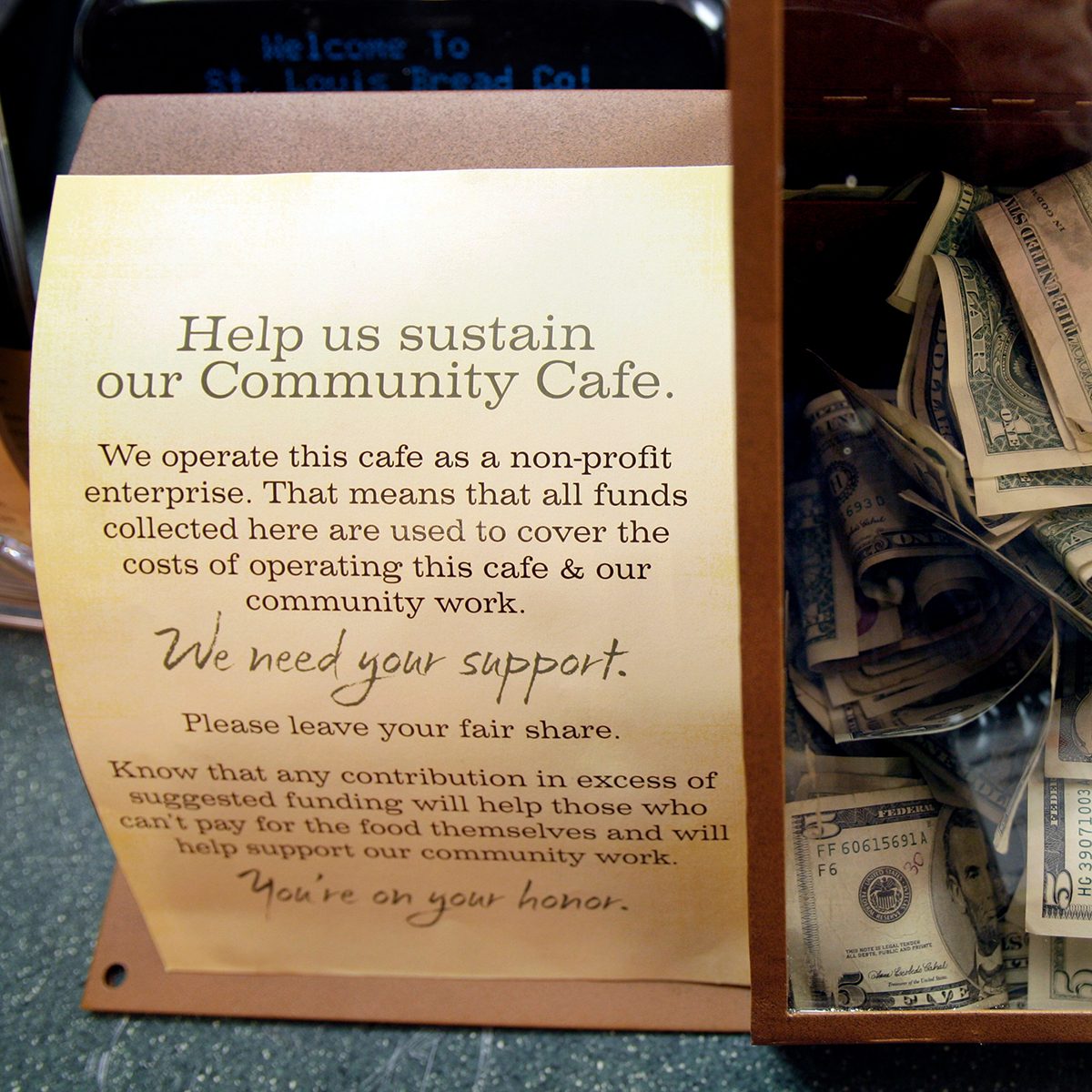 Cash paid for food items sits in a box at the front counter inside a Panera Bread Co. restaurant, in Clayton, Mo.