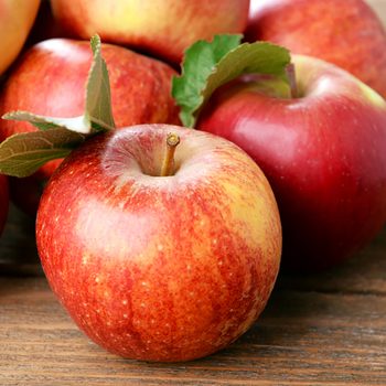 Ripe red apples on wooden background