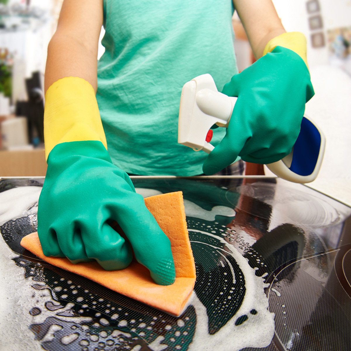 Young woman cleaning stove in her kitchen; Shutterstock ID 247066327; Job (TFH, TOH, RD, BNB, CWM, CM): Taste of Home