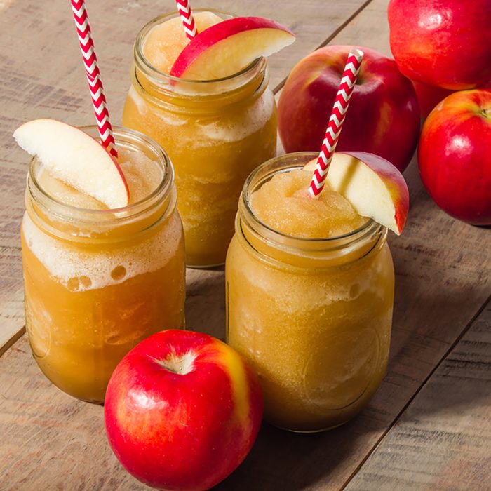 Red apples with frozen apple slushy drink in mason jar