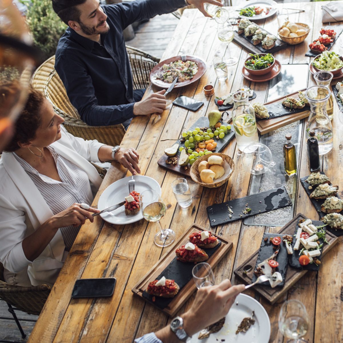 Group of men and women enjoying outdoor dinner celebration.