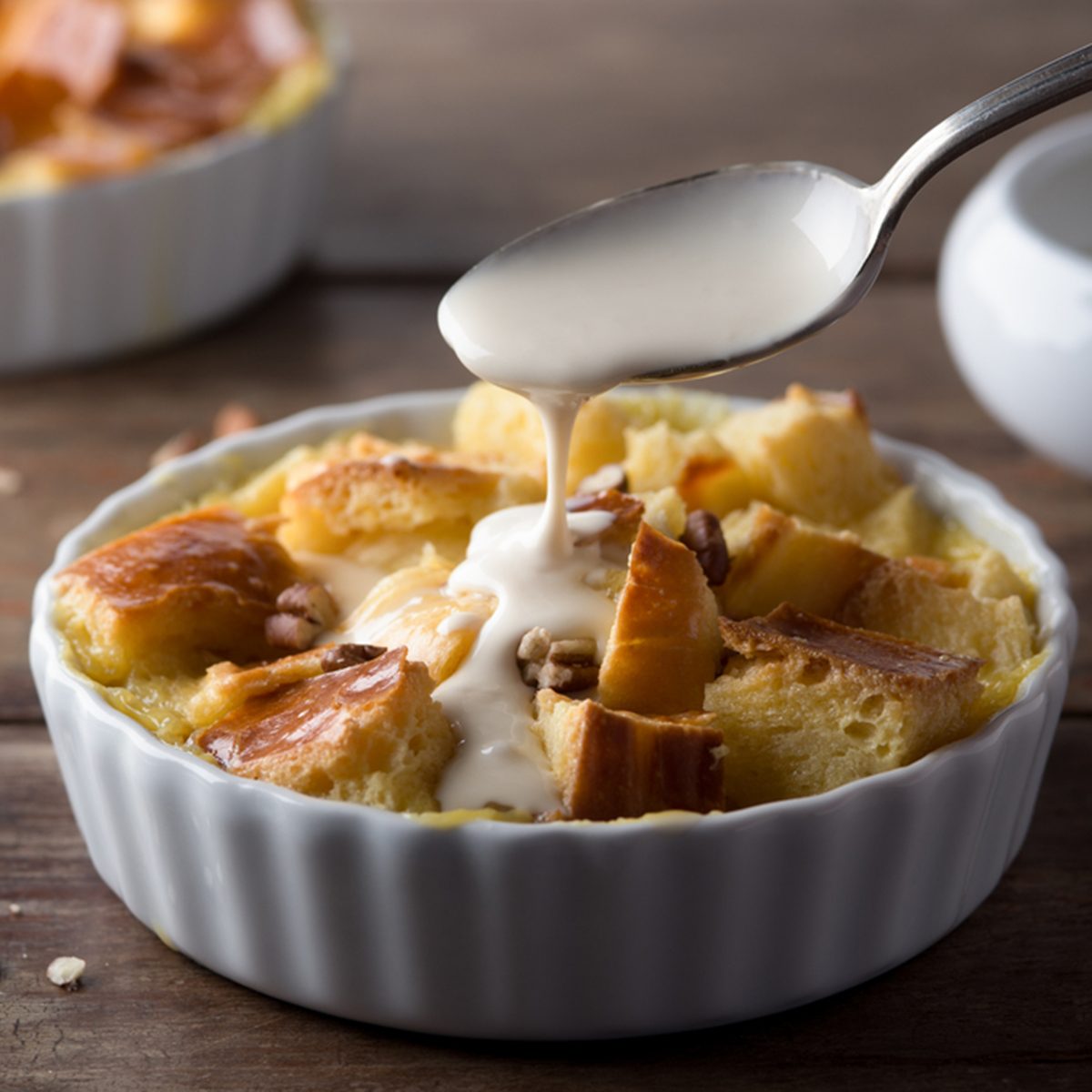 Pouring Maple Cream Sauce over Bread Pudding; Shutterstock ID 176583581; Job (TFH, TOH, RD, BNB, CWM, CM): Taste of Home
