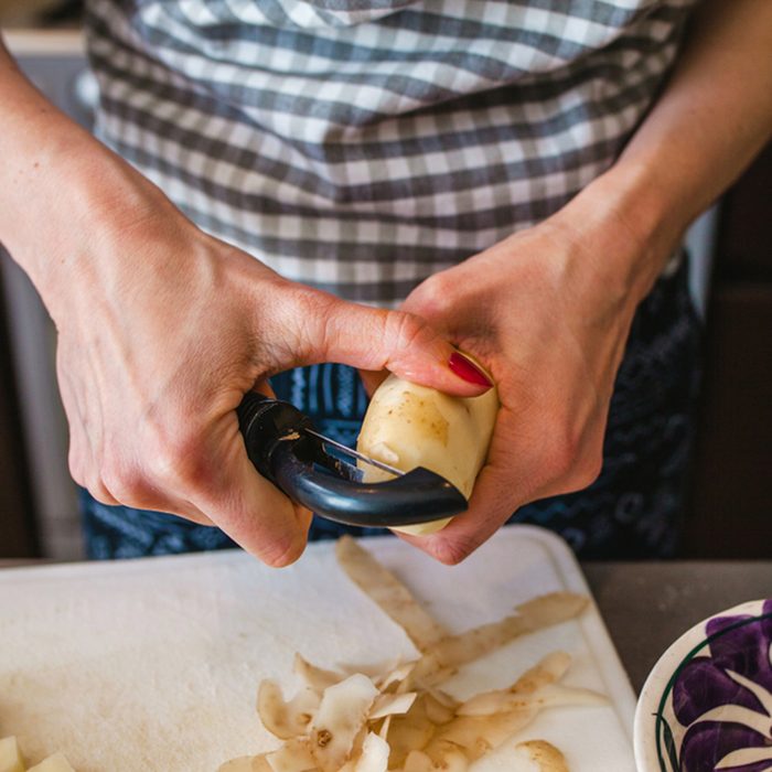 potato is peeled, woman hands, cooking food in kitchen