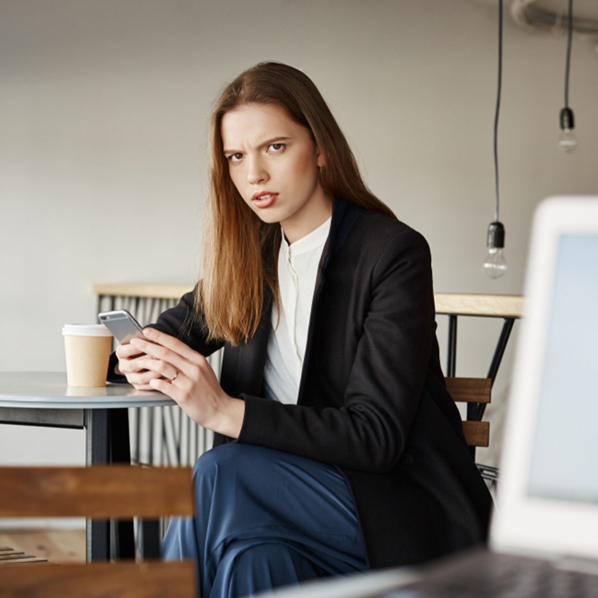 Woman is insulter with offensive words of stranger sitting with laptop.
