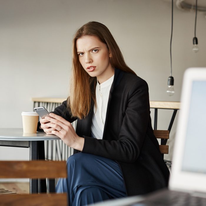 Woman is insulter with offensive words of stranger sitting with laptop.