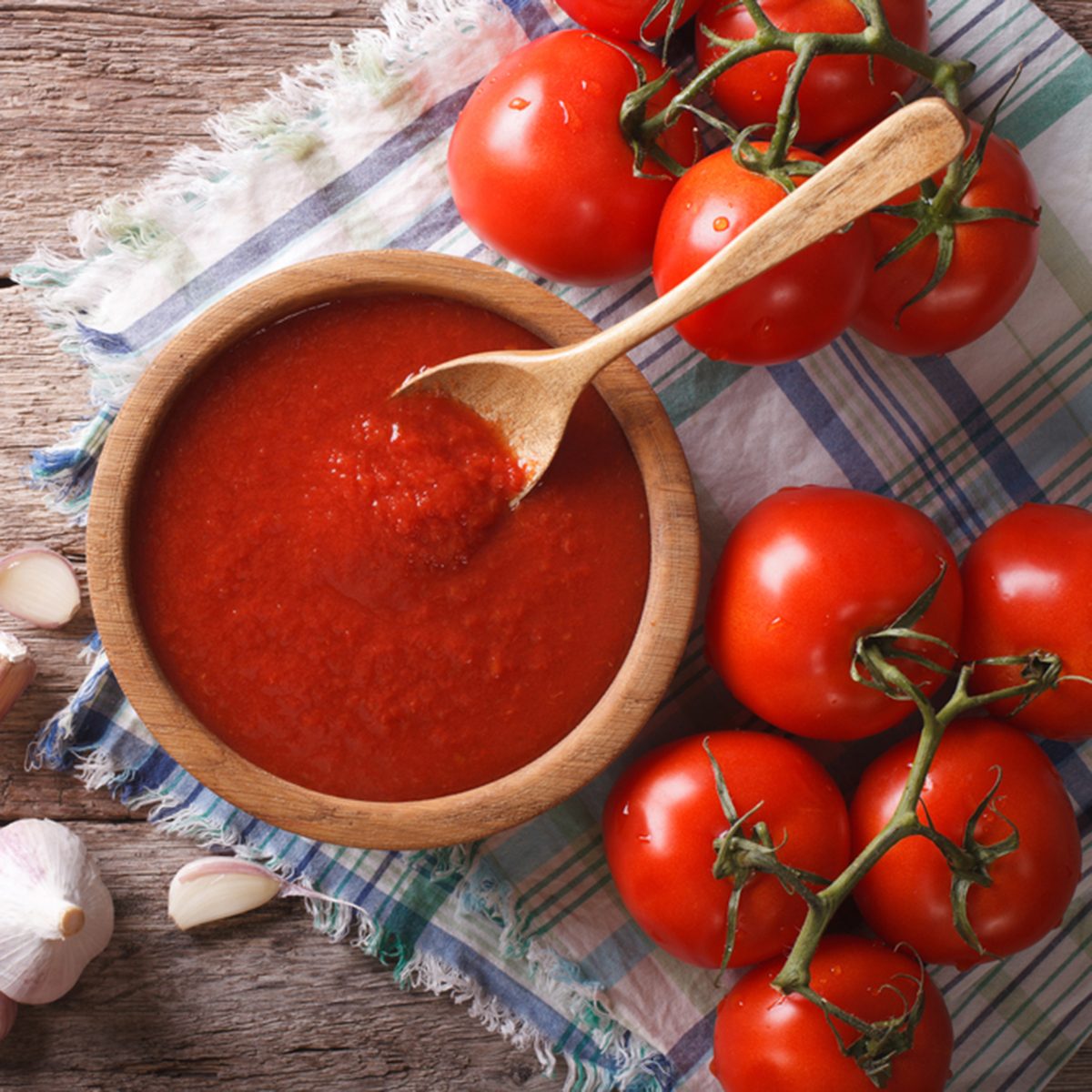Tomato sauce with garlic and basil in a wooden bowl. horizontal view from above