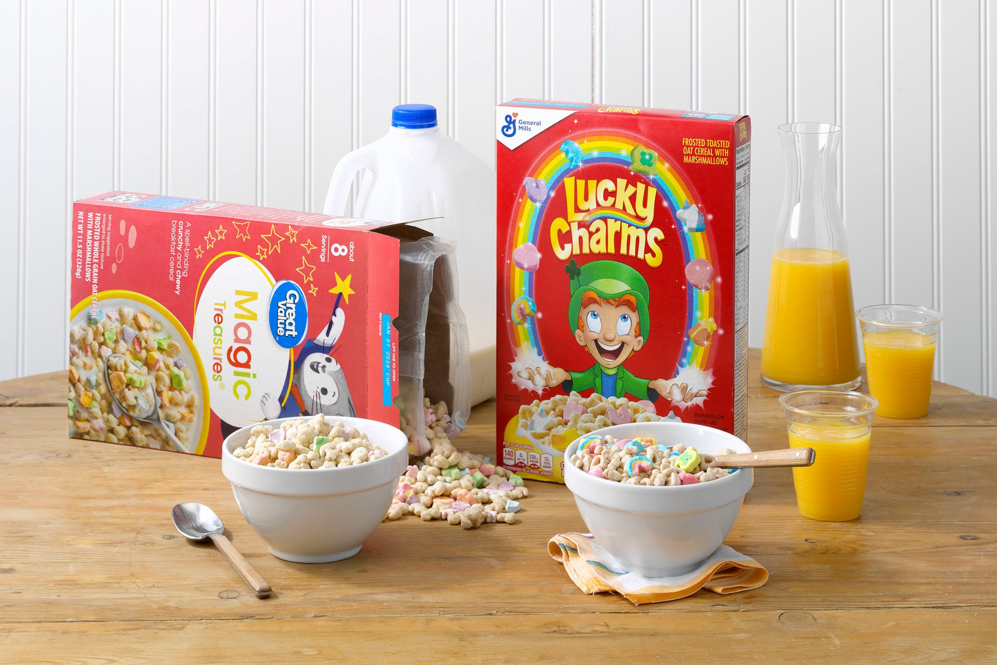 General Mills' Lucky Charms and Walmart's Great Value Magic Treasures on a wood table with orange juice and milk