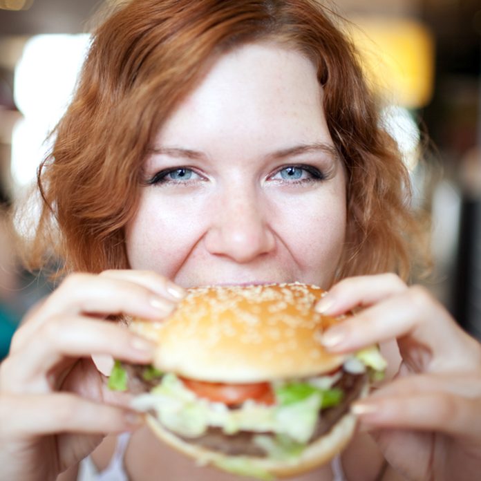 beauty woman in cafe eating hamburger