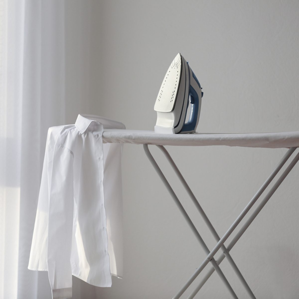 Modern iron and shirt on board