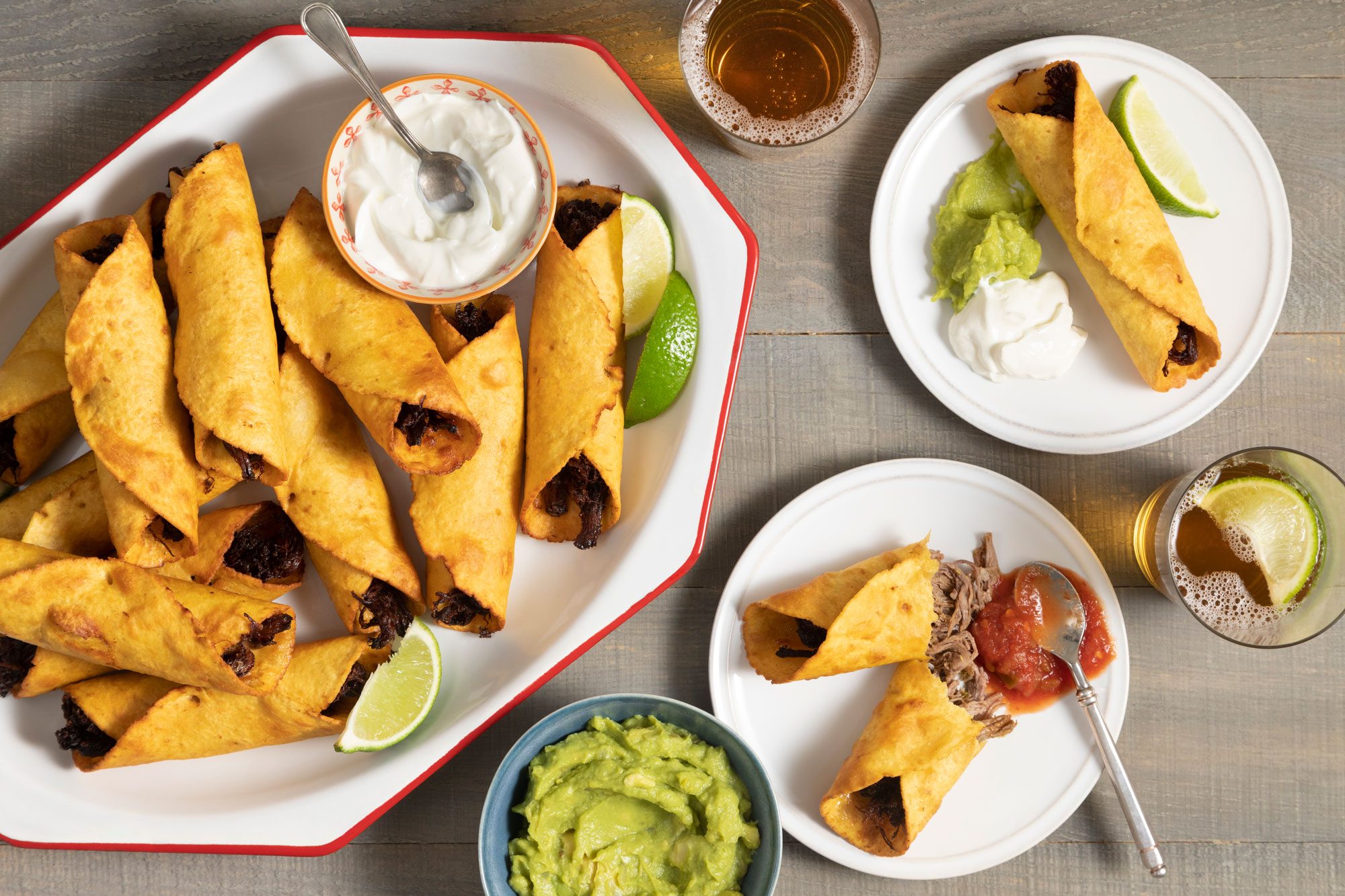 Beef Flautas served in a plate with guacamole and beer