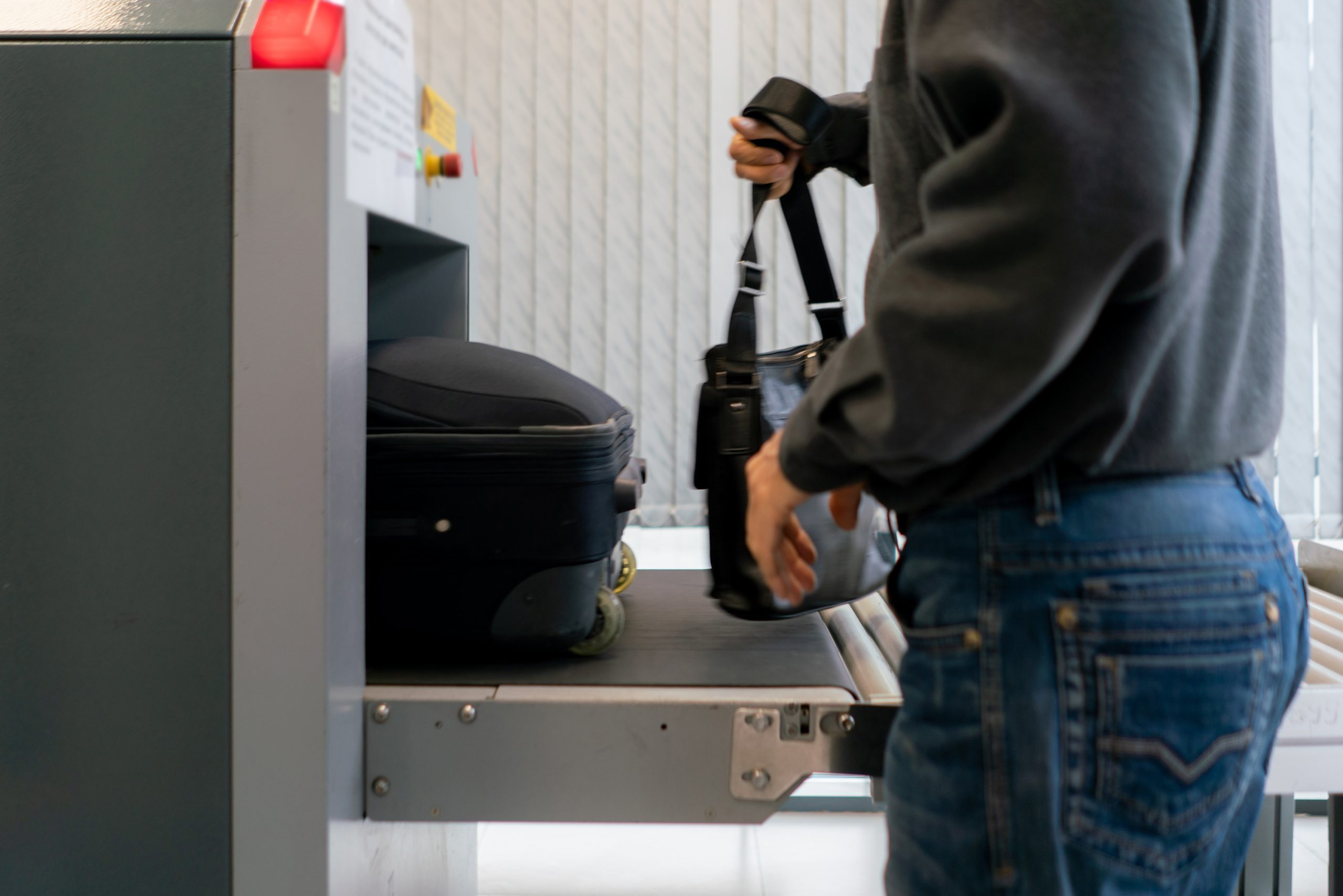 man going through xray at tsa security checkpoint in airport