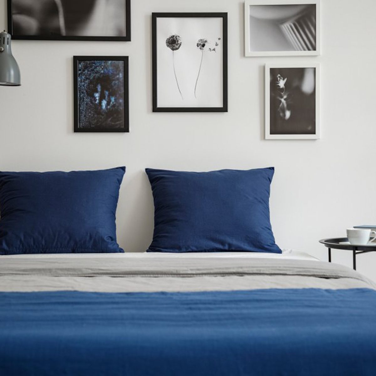 Blue bed with framed photos overhead