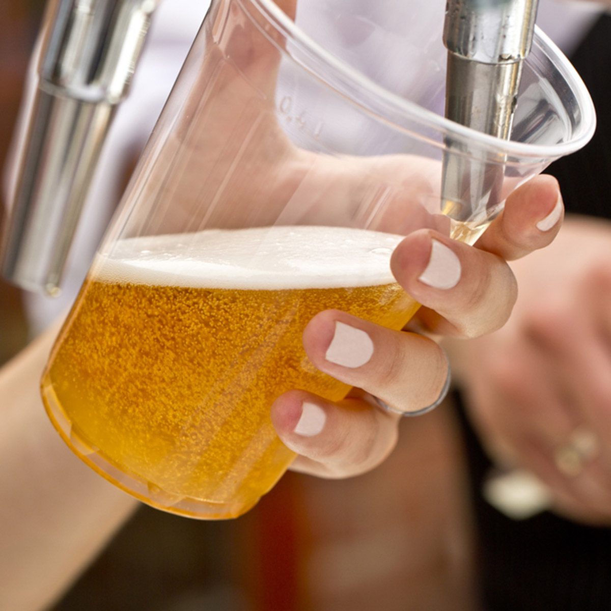 Pouring a plastic glass of beer