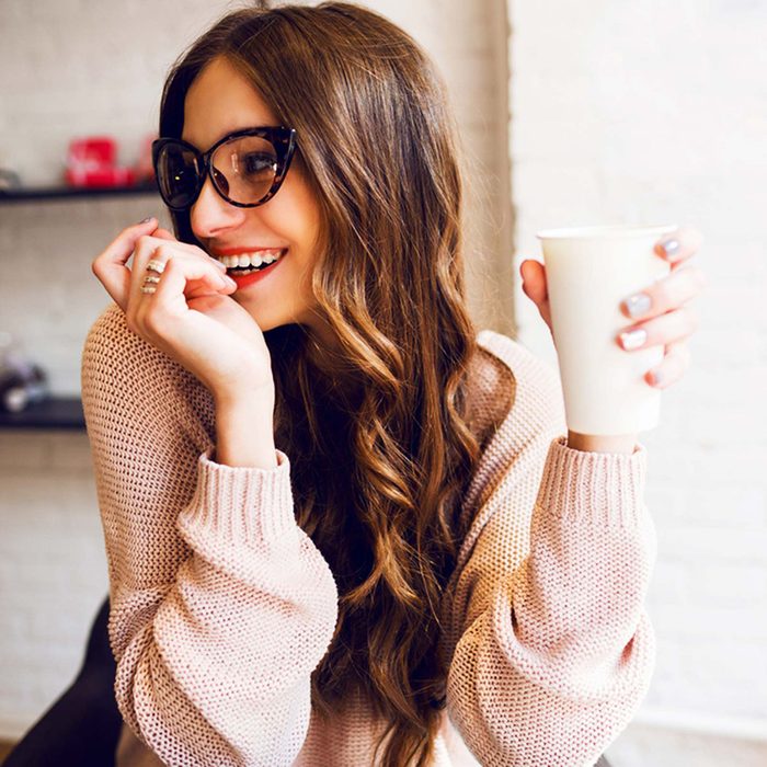 Woman laughing and holding mug