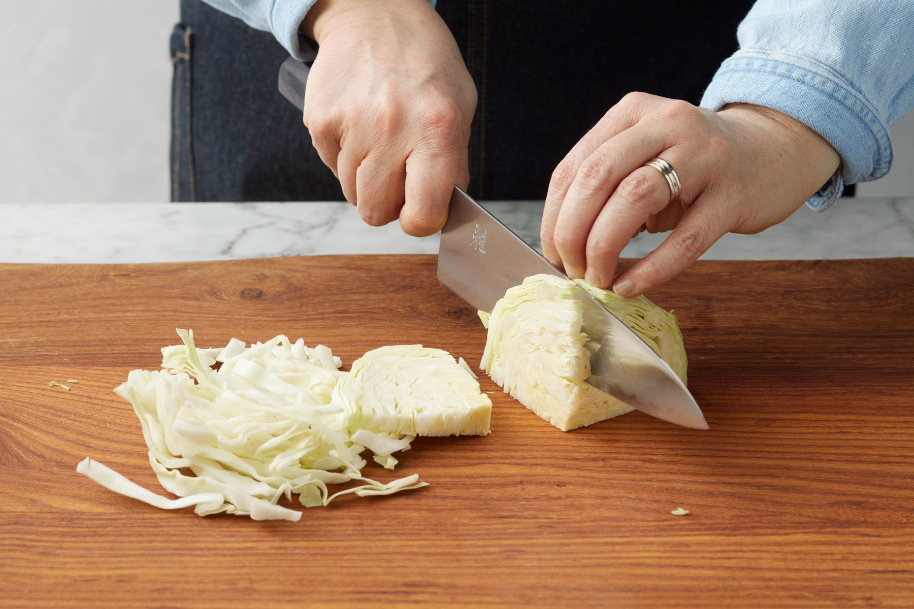 Cabbage Being Chopped On Cutting Board with a knife