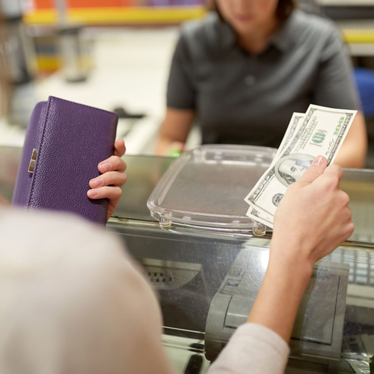 Woman paying money and cashier at store cash register