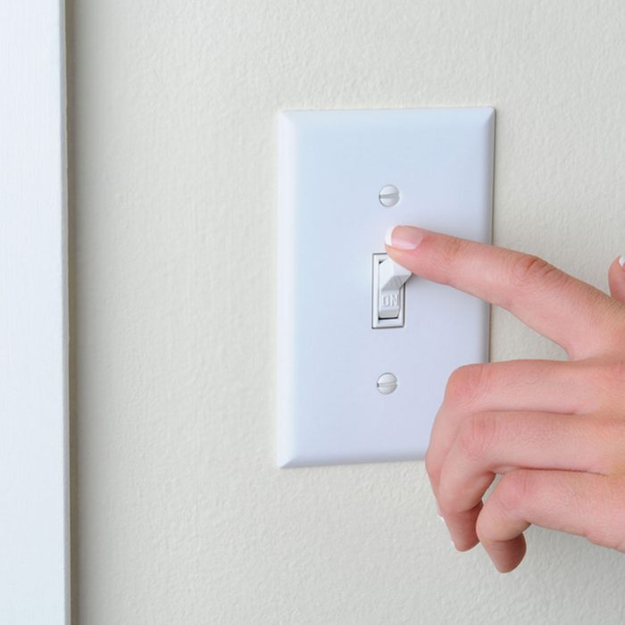Womans hand with finger on light switch, about to turn off the lights. Closeup of hand and switch only. Horizontal format.; Shutterstock ID 95322187; Job (TFH, TOH, RD, BNB, CWM, CM): Taste of Home