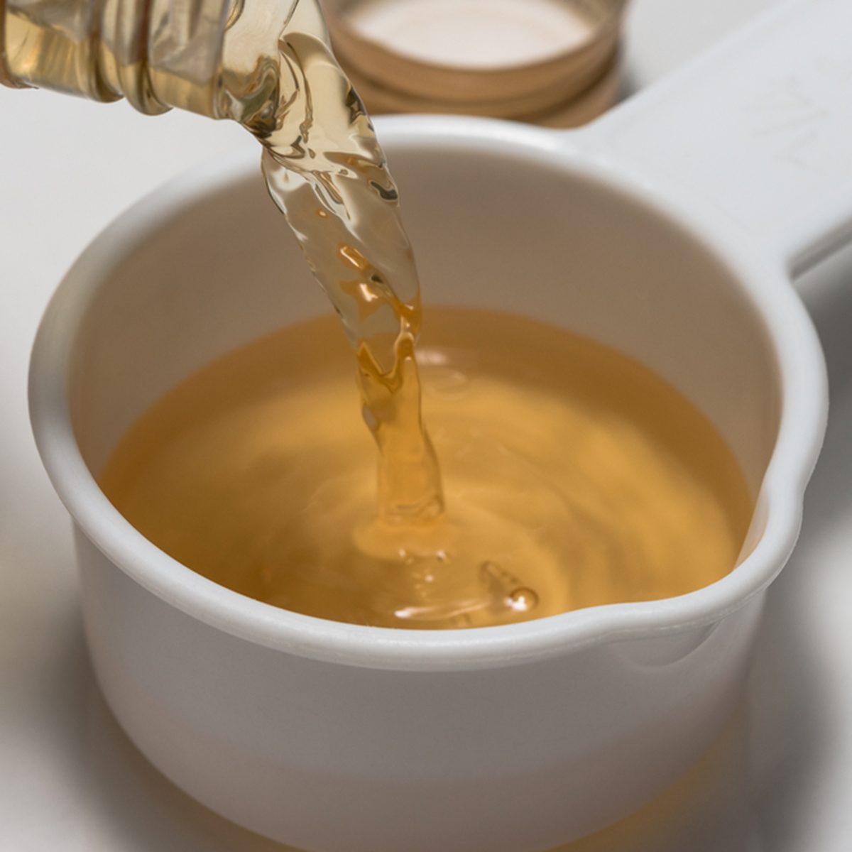 Pouring a quarter cup of apple cider vinegar